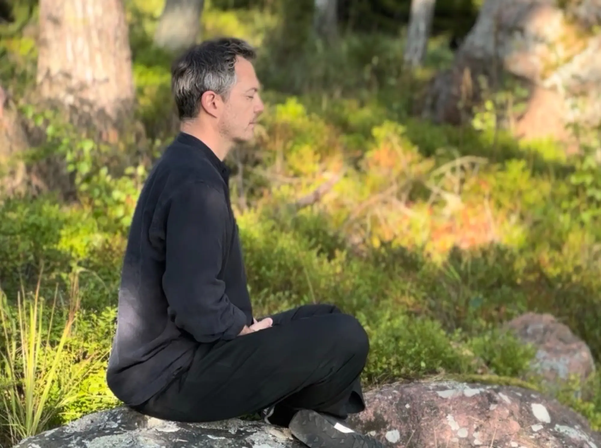 Darren Rose meditating outdoors, reflecting his whole-person approach to health